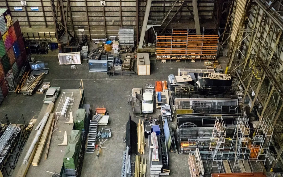 Groot magazijn met hoge stellingen en verschillende zones
