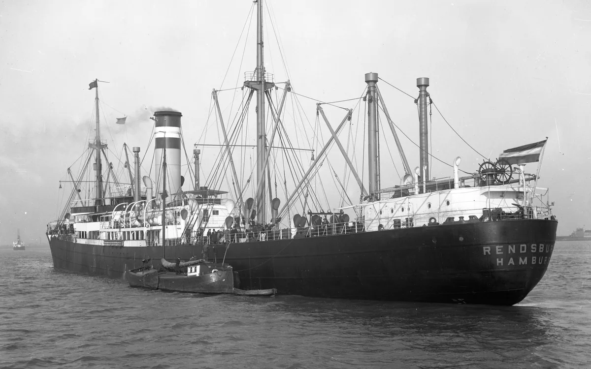 Binnenvaartschip wordt geladen aan een bedrijfskade