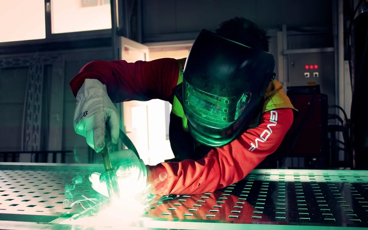 Lasser aan het werk aan een metalen constructie